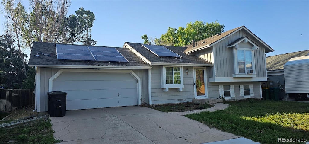 21225 E Powers Ave, Centennial, CO 80015 - tri-level home featuring driveway, roof mounted solar panels, an attached garage, and board and batten siding