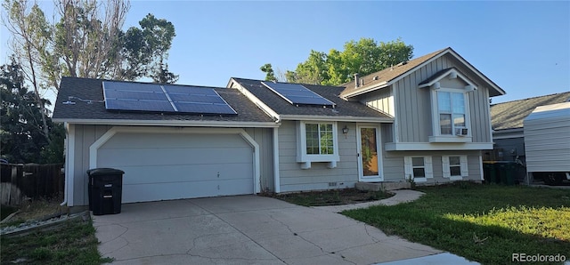 21225 E Powers Ave, Centennial, CO 80015 - tri-level home featuring driveway, roof mounted solar panels, an attached garage, and board and batten siding