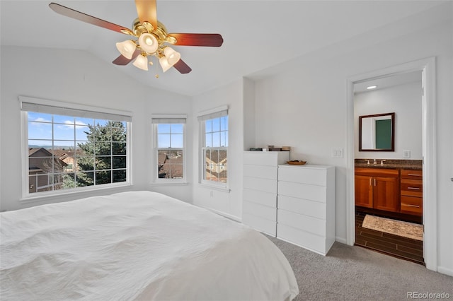 bedroom featuring ceiling fan, multiple windows, connected bathroom, and sink