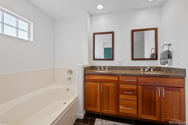 bathroom featuring tiled bath, tile patterned flooring, and vanity