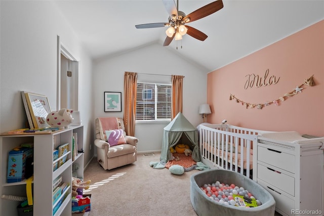 bedroom featuring ceiling fan, a nursery area, vaulted ceiling, and light carpet