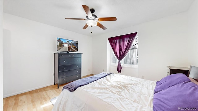 bedroom with baseboards, ceiling fan, and wood finished floors
