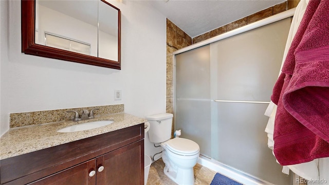 full bath featuring vanity, a stall shower, and toilet