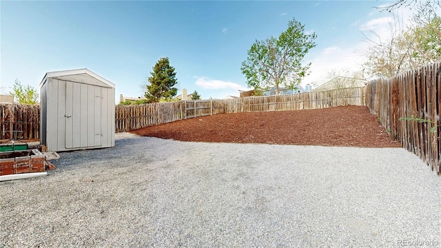 view of yard with a storage shed, an outbuilding, and a fenced backyard