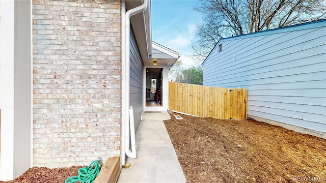 view of home's exterior featuring fence and brick siding