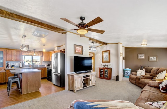 living room featuring ceiling fan, lofted ceiling with beams, light carpet, and a textured ceiling