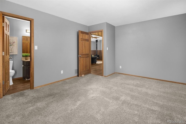 32252 Steven Way, Conifer, CO 80433 - unfurnished bedroom featuring carpet flooring, a wood stove, and ensuite bathroom
