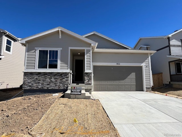 view of front of house with a garage, stone siding, and concrete driveway