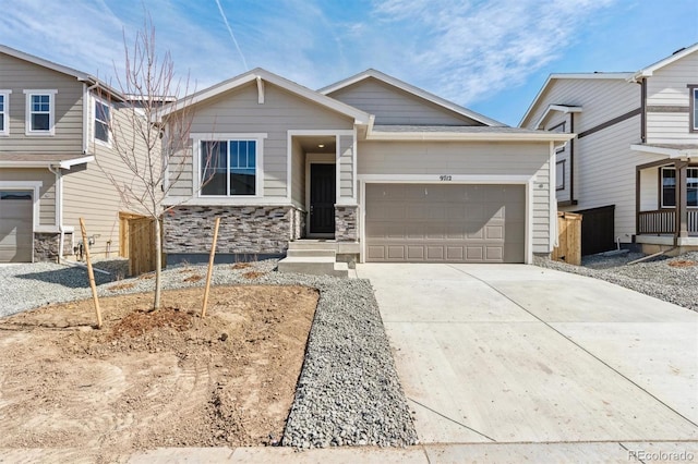 view of front facade with stone siding, an attached garage, and driveway