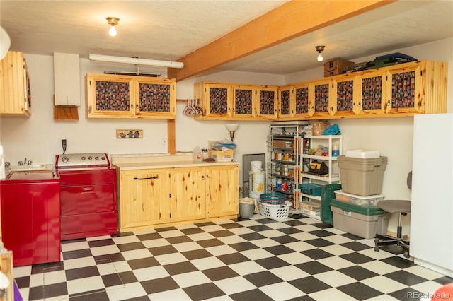 kitchen with tile patterned floors, independent washer and dryer, light countertops, and a sink