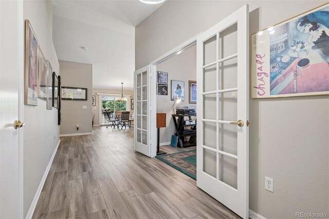 9747 W Peakview Dr, Littleton, CO 80123 - hall featuring french doors, wood finished floors, and a chandelier