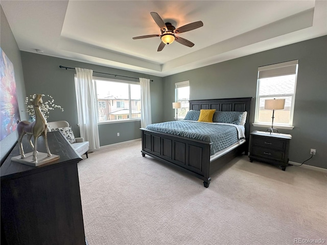9482 Kendrick Way, Arvada, CO 80007 - bedroom featuring a tray ceiling, light carpet, baseboards, and a ceiling fan