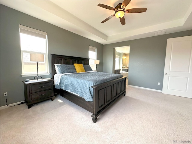 9482 Kendrick Way, Arvada, CO 80007 - bedroom with a tray ceiling, multiple windows, light carpet, and ensuite bathroom
