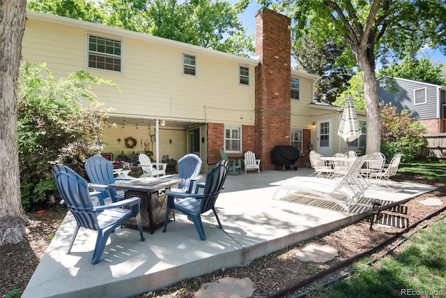 6624 S Sycamore St, Littleton, CO 80120 - rear view of property with a patio, a chimney, and an outdoor fire pit