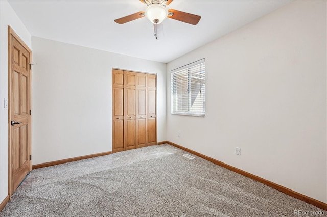 unfurnished bedroom featuring ceiling fan, carpet flooring, visible vents, baseboards, and a closet