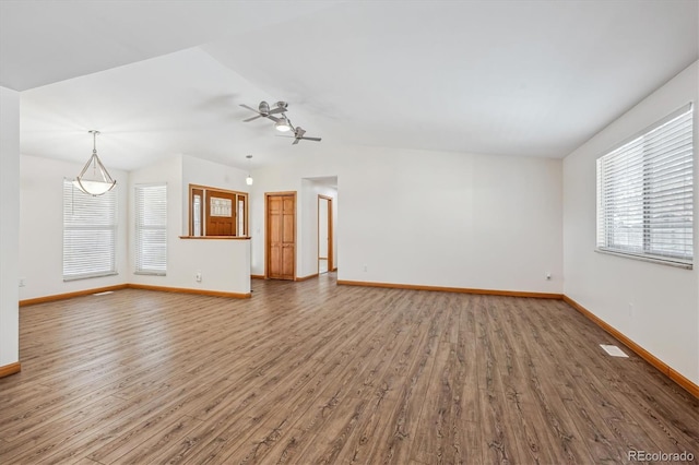 unfurnished living room with lofted ceiling, visible vents, baseboards, and wood finished floors