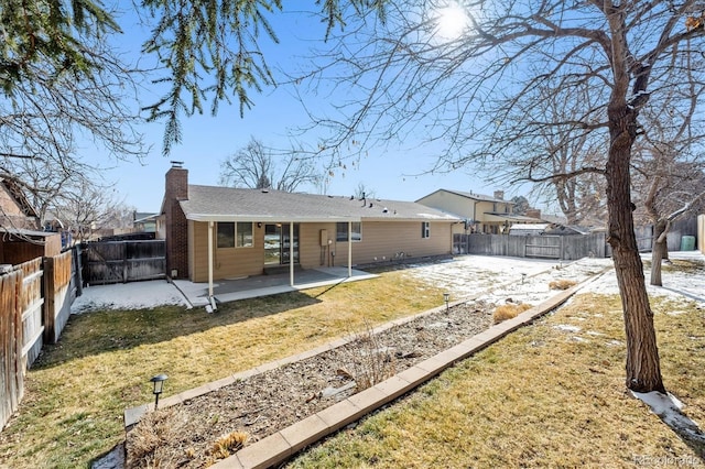 rear view of house featuring a chimney, a patio area, a yard, and a fenced backyard