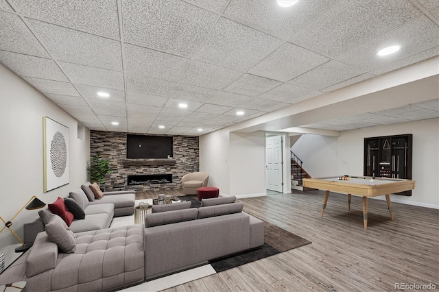 living room with a fireplace, recessed lighting, wood finished floors, baseboards, and stairs