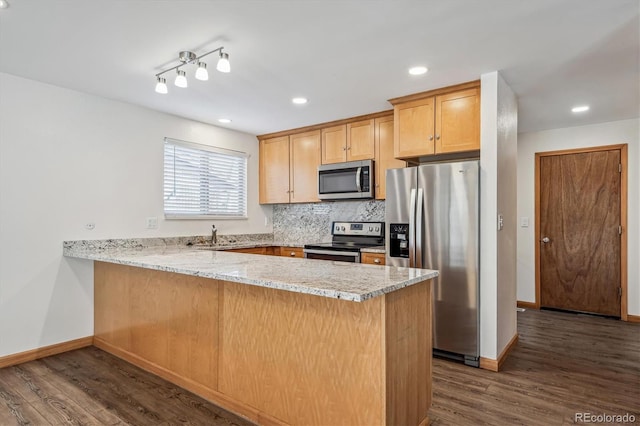 kitchen featuring stainless steel appliances, a peninsula, decorative backsplash, and dark wood-style floors