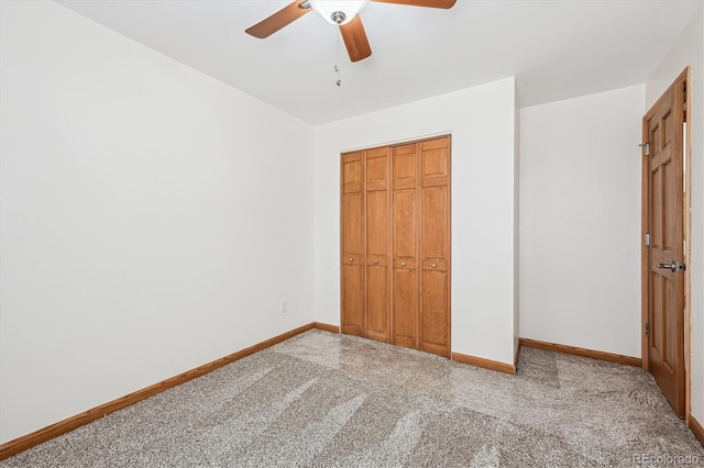 unfurnished bedroom featuring a ceiling fan, a closet, carpet flooring, and baseboards