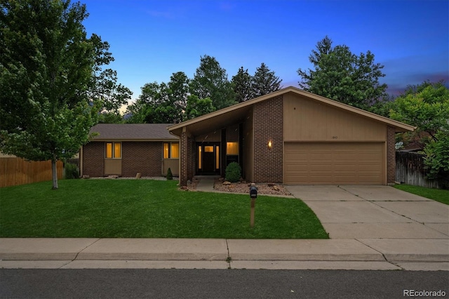 1843 S Pierson Ct, Lakewood, CO 80232 - mid-century modern home featuring a garage, brick siding, and driveway