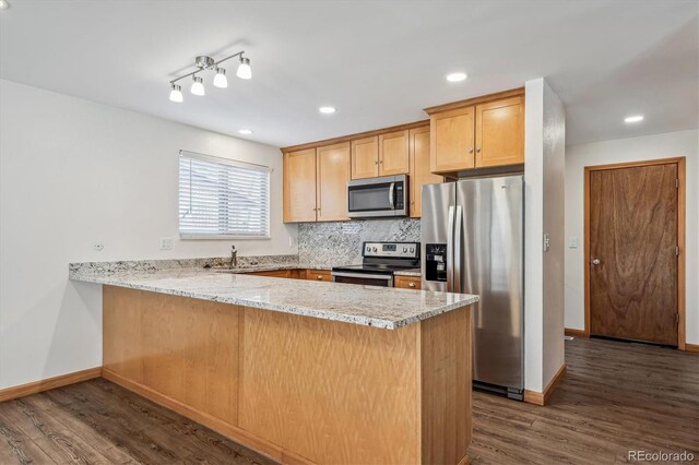 1843 S Pierson Ct, Lakewood, CO 80232 - kitchen featuring appliances with stainless steel finishes, a peninsula, dark wood-type flooring, light stone countertops, and tasteful backsplash
