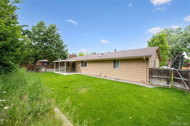 1843 S Pierson Ct, Lakewood, CO 80232 - back of house with a patio area, a fenced backyard, and a chimney