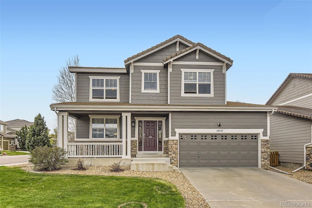 craftsman house with a garage, stone siding, a front yard, concrete driveway, and a porch