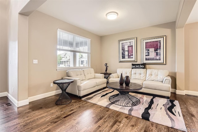 living area with baseboards and wood finished floors