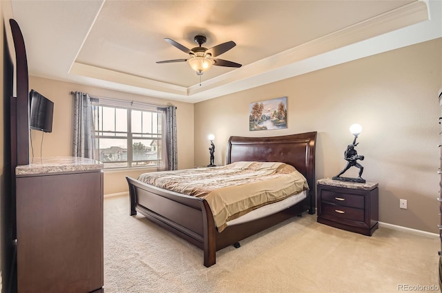 bedroom featuring a tray ceiling, light carpet, and baseboards