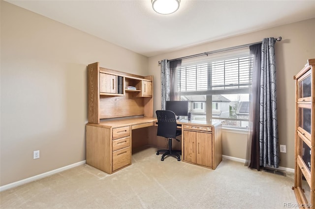 office space with baseboards and light carpet