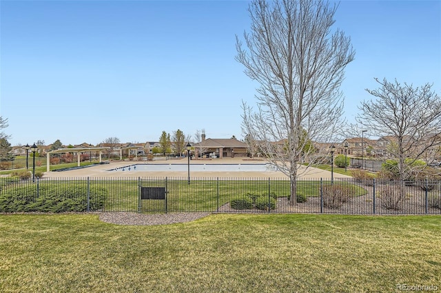 view of community with a yard, fence, a residential view, and a pool