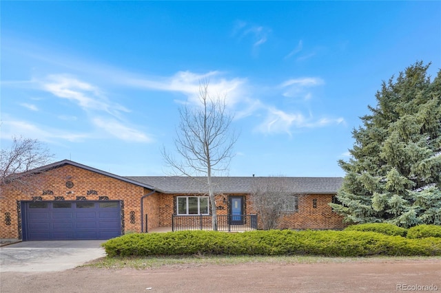 single story home with brick siding, driveway, and an attached garage
