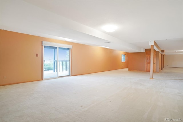 below grade area featuring light colored carpet and baseboards