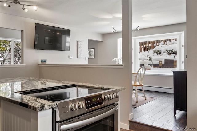 kitchen with stainless steel electric stove, dark wood-type flooring, stone counters, and a baseboard radiator