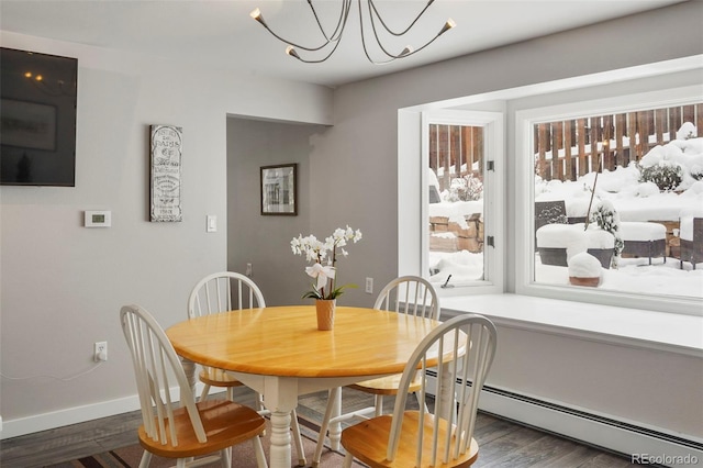 dining room with dark hardwood / wood-style flooring, an inviting chandelier, and baseboard heating