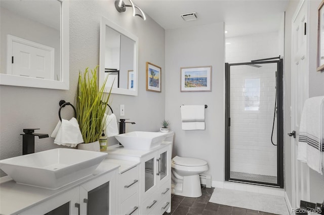 bathroom featuring tile patterned flooring, vanity, toilet, and walk in shower