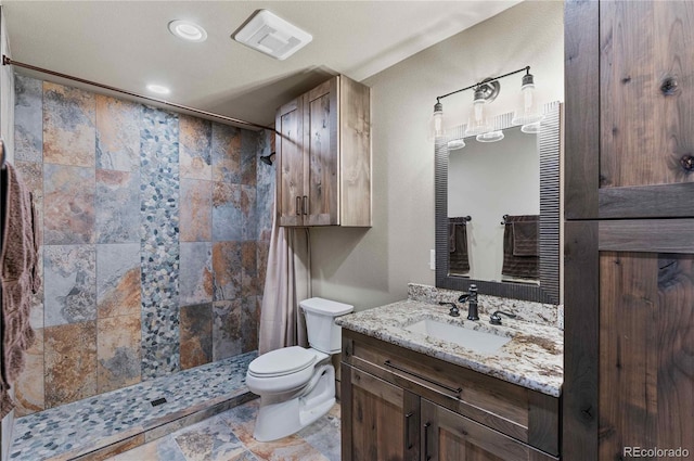 bathroom featuring toilet, vanity, and walk in shower