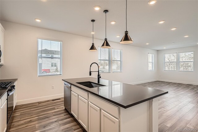 6874 Zuni Ct, Denver, CO 80221 - kitchen with a sink, dark countertops, gas stove, wood finished floors, and recessed lighting