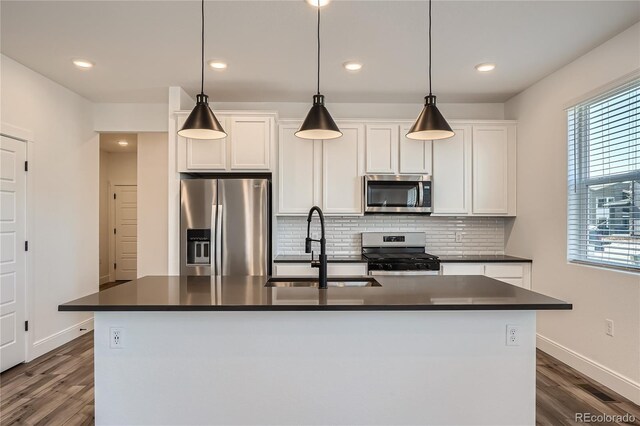 6874 Zuni Ct, Denver, CO 80221 - kitchen featuring stainless steel appliances, a sink, dark countertops, dark wood-style floors, and recessed lighting