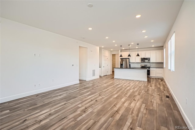 6874 Zuni Ct, Denver, CO 80221 - unfurnished living room featuring light wood-style flooring, recessed lighting, and baseboards