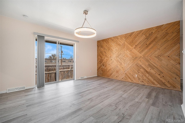 unfurnished room featuring hardwood / wood-style floors and wood walls