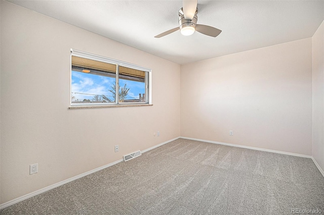 carpeted spare room featuring ceiling fan