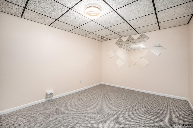 empty room featuring a drop ceiling and carpet