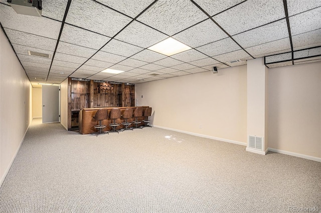 basement with a paneled ceiling and carpet floors