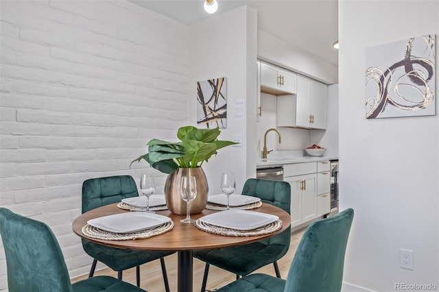 dining area with light wood-style floors and beverage cooler