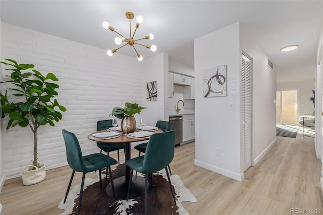 dining space with visible vents, baseboards, a chandelier, and light wood finished floors