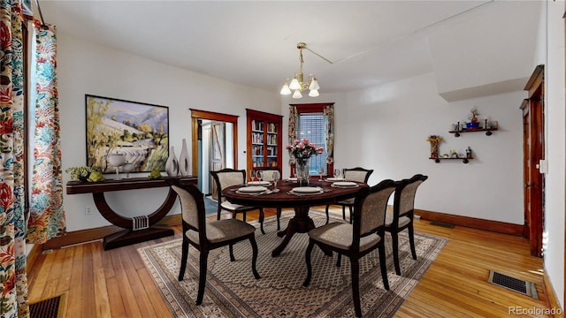 dining space featuring a notable chandelier and hardwood / wood-style flooring