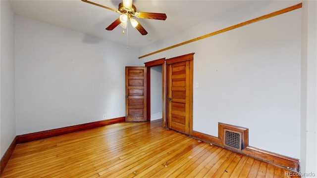 empty room with ceiling fan and light hardwood / wood-style flooring