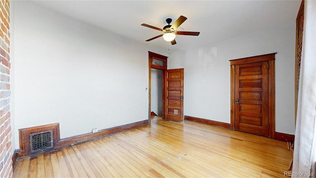 empty room with ceiling fan and light hardwood / wood-style flooring